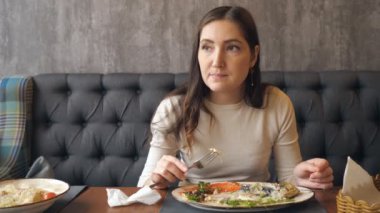 Genç kadın restoranda akşam yemeği yeme.