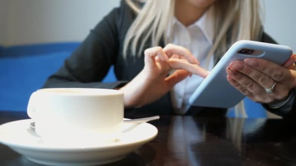 Ragazza irriconoscibile con telefono in un caffè — Video Stock