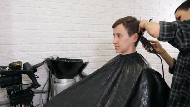 Friseurin schneidet Haare mit Haarschneider — Stockvideo