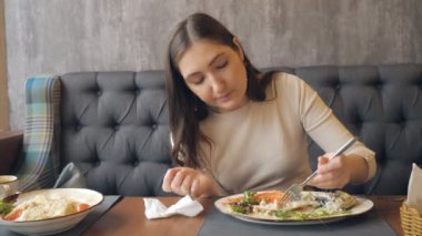 Genç kadın restoranda akşam yemeği yeme.