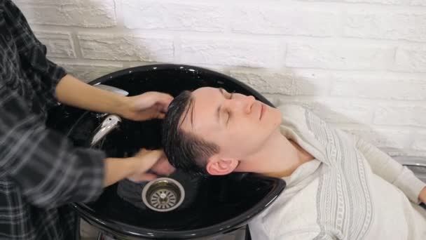Cabeleireiro fêmea lava um homem cabeça na barbearia — Vídeo de Stock