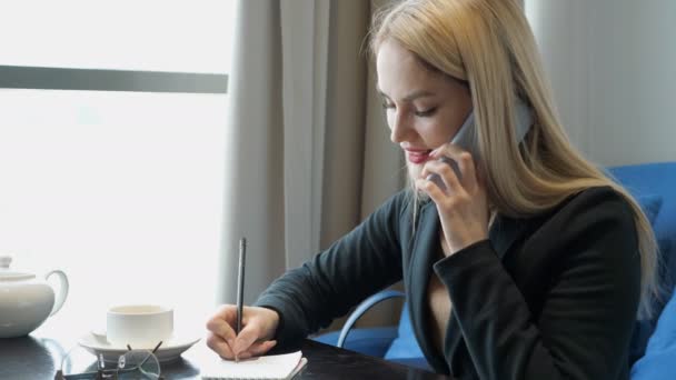 Jeune femme d'affaires en costume assis à la table dans un café — Video