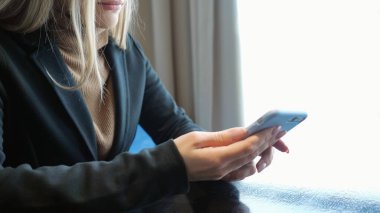 tanınmayan bir kafede bir masada oturan telefon kızla