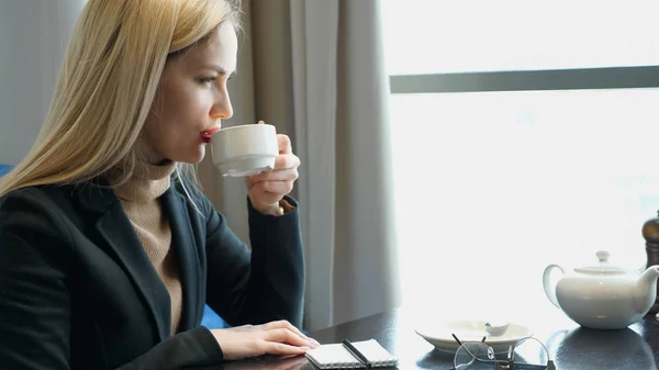 Mujer rubia disfrutar de beber café caliente con sentirse bien en la cafetería —  Fotos de Stock