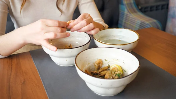 Manos femeninas limpia y come camarones en la cafetería —  Fotos de Stock