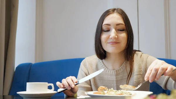 Mujer comiendo ensalada sentada en la cafetería —  Fotos de Stock