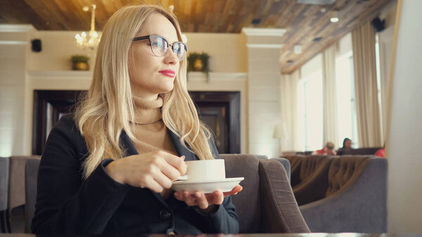 Blonde woman enjoy drinking hot coffee with feeling good in cafe