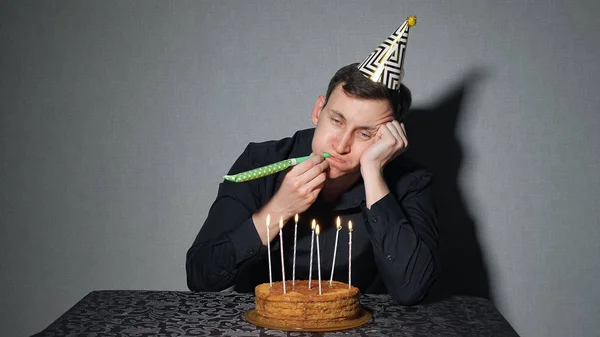 Triste homem solitário em chapéu de festa celebrando aniversário sozinho — Fotografia de Stock