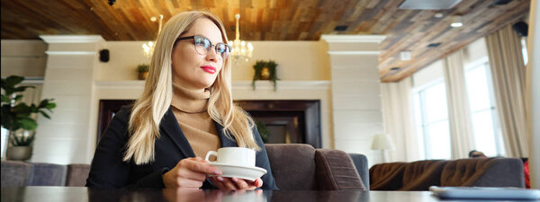 Blonde woman enjoy drinking hot coffee with feeling good in cafe