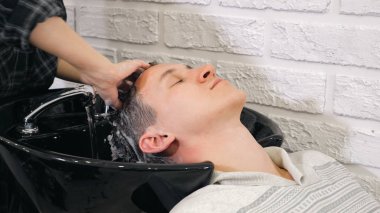 Kuaför yıkama karanlık eller erkek saç altında çalışan su içinde Berber Dükkanı.