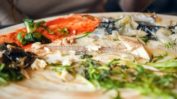 Жінка їсть залишки риби з ножем і виделкою в кафе — стокове фото