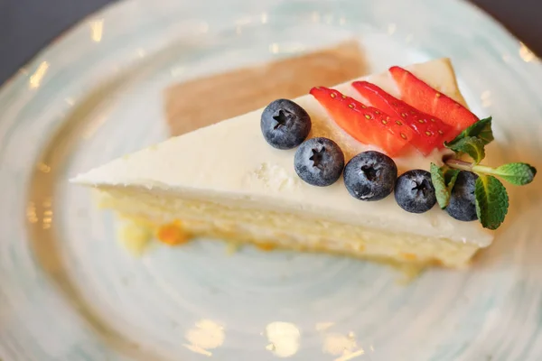 Un pedazo de pastel con fresa y arándano en el plato —  Fotos de Stock