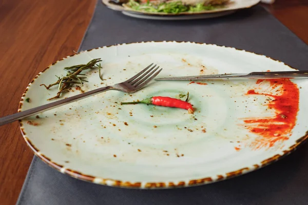 Plato con tenedor y cuchillo en la mesa después de la cena —  Fotos de Stock
