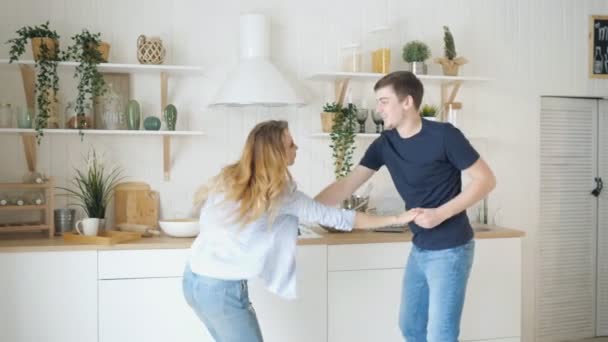 Rubia chica chico danza por mesa estufa en moderno cocina — Vídeos de Stock