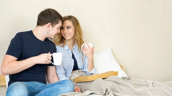 Dziewczynka facet zjeść śniadanie w łóżku pić kawy talk uśmiechający się — Zdjęcie stockowe