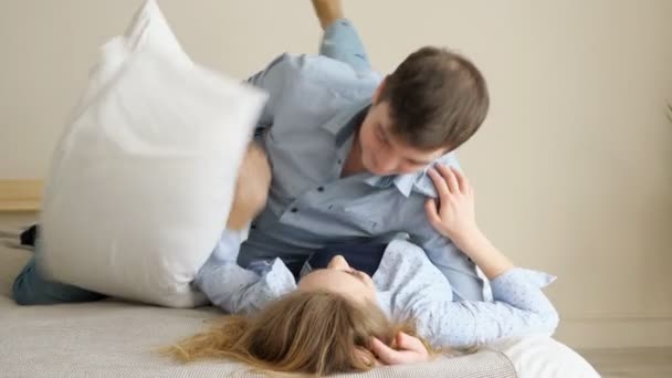 Lány srác esik le az ágyra stroke és megcsókolják egymást — Stock videók