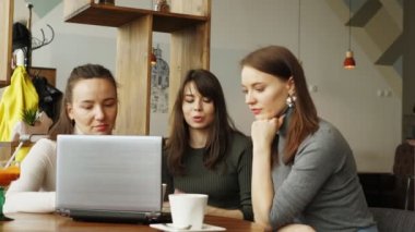 İş arkadaşları kadınlar kafede bir dizüstü bilgisayar kullanarak ortak projeyi tartışmak.