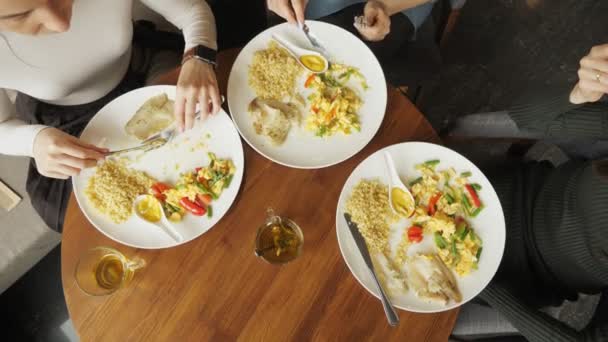 Vrienden van de drie vrouwen zijn hun eten in café. Gerechten op tafel — Stockvideo