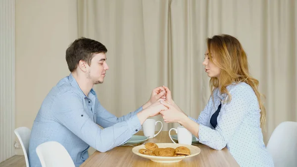Couple sits at table join hands and pray before breakfast — Stock Photo, Image