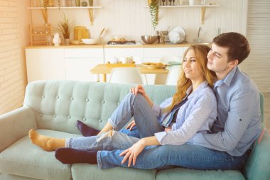 adam kanepede oturan ve mutfakta öpüşme Bayan hugs