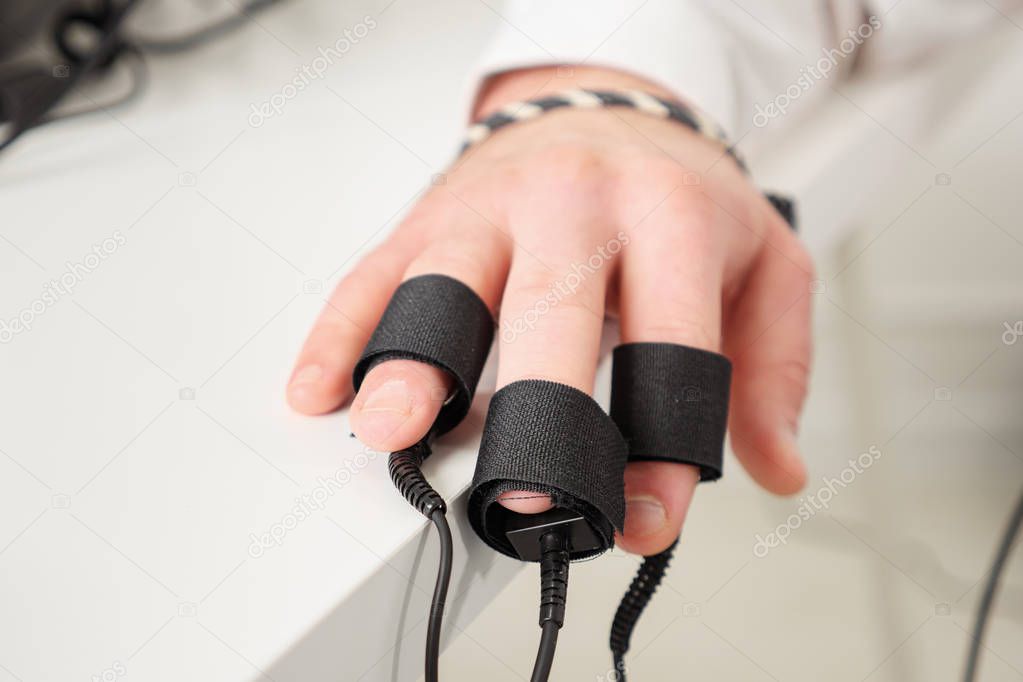 mans hands on which polygraph sensors are worn