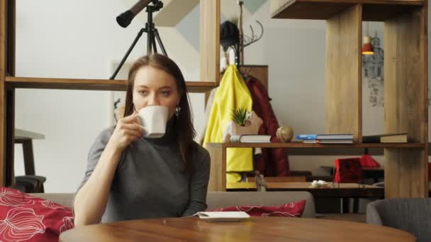 Молодая женщина встречается в кафе, чтобы выпить чашку кофе . — стоковое видео