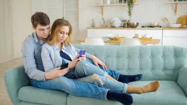 adam sarışın kız kanepe dalga köpüğü enterne smartphones içinde oturmak