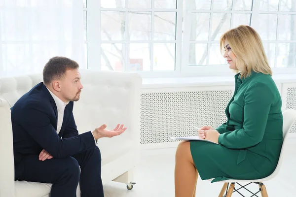 Hombre de negocios sentado en el sofá hablando con la psicóloga — Foto de Stock