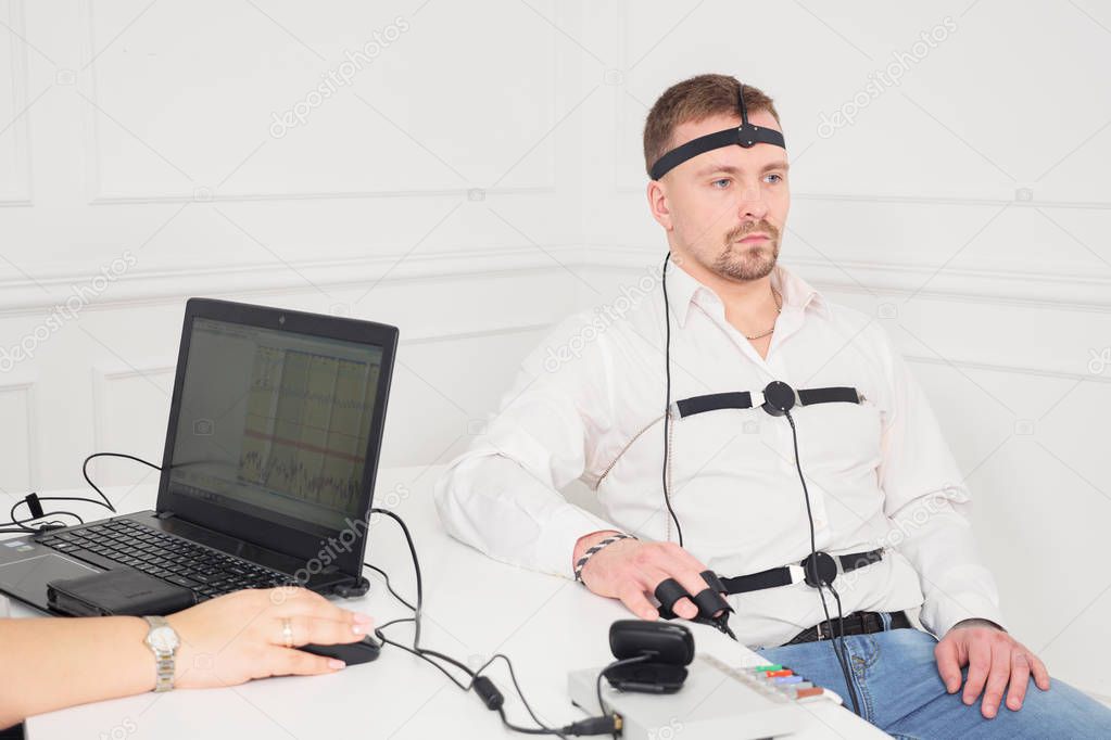 businessman sits for a lie detector examination