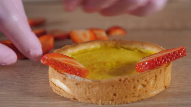 Pastelero está haciendo mini pastel con crema y rodajas de fresa . — Vídeos de Stock