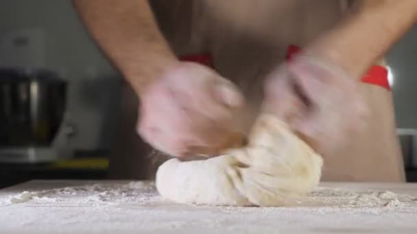 Chef padeiro amassa massa com farinha na mesa . — Vídeo de Stock