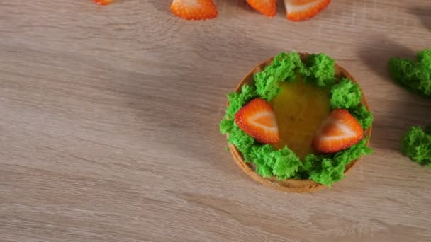 Chef pâtissier fait mini gâteau avec des tranches de crème et de fraise . — Video