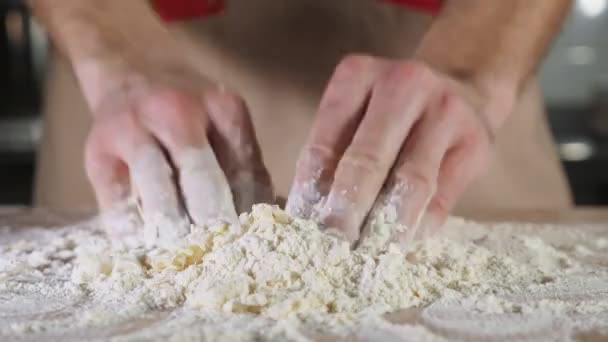 Chef panettiere sta impastando la pasta con la farina a mano sul tavolo — Video Stock