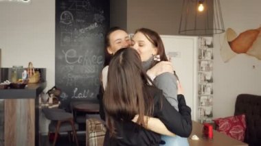 Üç kadın arkadaş birlikte tebrik sarılıyorlar. Kafede dostu Toplantı.
