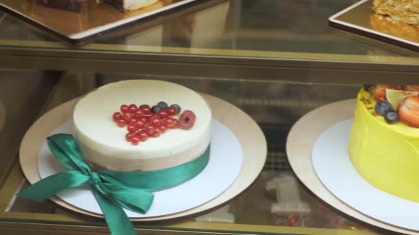 Vitrine de boulangerie avec gâteaux et pâtisseries sur étagères en verre . — Video