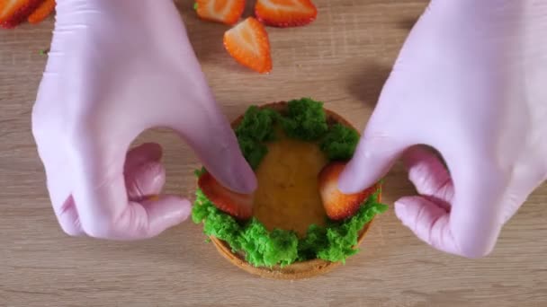 Pastry chef is making mini cake with cream and strawberry slices. — Stock Video