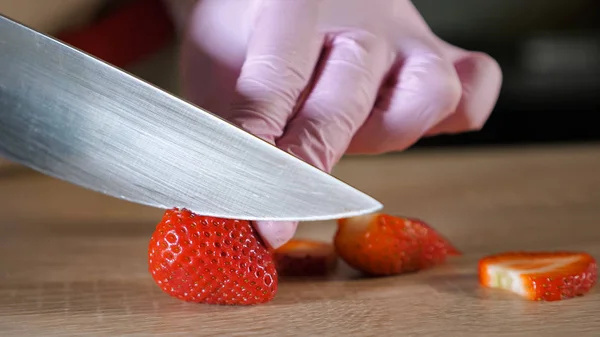 Chef cook cuts strawberries on a cutting board — Stock Photo, Image