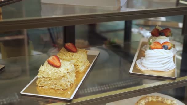Bageri VITRINE med kakor och bak verk på glas hyllor. — Stockvideo