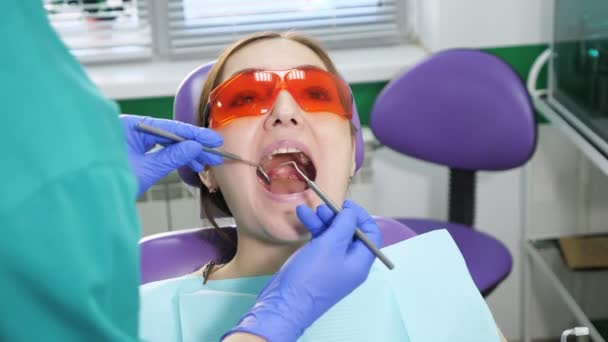 Mujer joven en examen preventivo en silla dental en el dentista. Concepto de cuidado dental . — Vídeo de stock