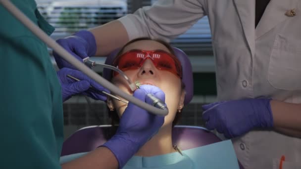 Diş hekimi elektrikli diş fırçası kullanarak hastalar diş bakımı. Diş sandalyede kadın portresi. — Stok video