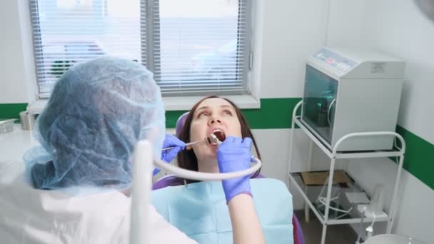 Młoda kobieta na badaniu profilaktycznym na krześle dentystycznym u dentysty. Koncepcja pielęgnacji zębów. — Wideo stockowe
