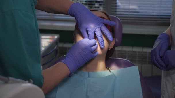 Tandarts is het verzorgen van patiënten tand met behulp van elektrische tandheelkundige borstel. Dames portret in Dental Chair. — Stockvideo