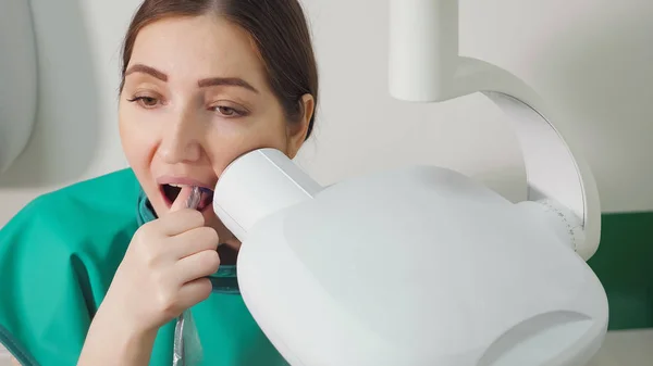 Jonge vrouw is het doen van tand x-ray in tandheelkundige kliniek — Stockfoto