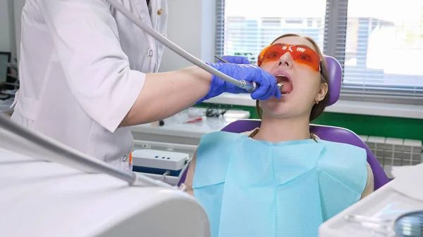 Tandarts behandeling tanden aan vrouw patiënt in kliniek. — Stockfoto