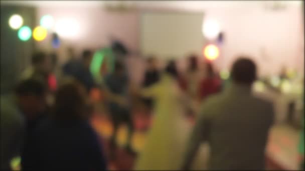 Люди танцюють на вечірці в нічному клубі з кольоровим світлом — стокове відео