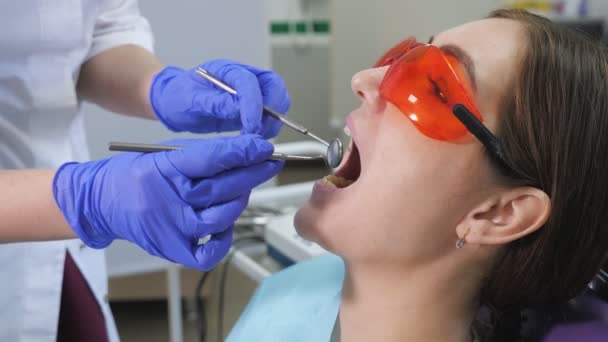 Giovane donna in visita preventiva in poltrona dentale dal dentista. concetto di cura dei denti . — Video Stock