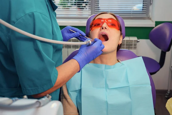 Tandarts behandeling tanden aan vrouw patiënt in kliniek. — Stockfoto