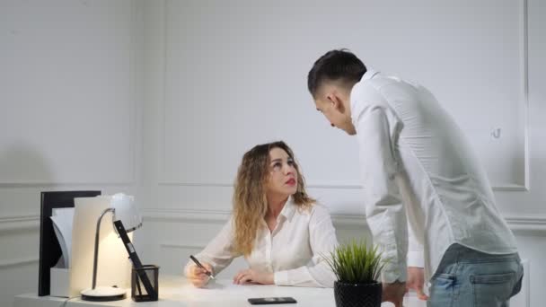 Colegas hombre y mujer están peleando entre sí en el lugar de trabajo . — Vídeos de Stock