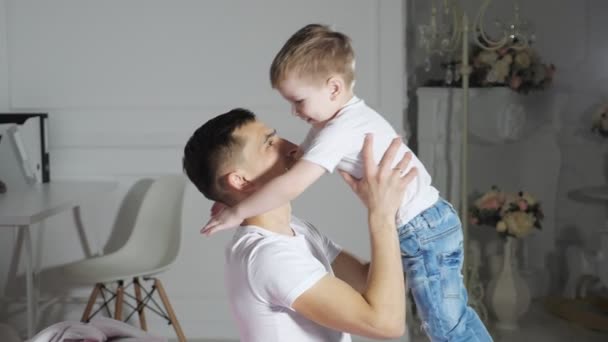 Pappa och son är kramar faller i sängen tillsammans, slow motion. — Stockvideo