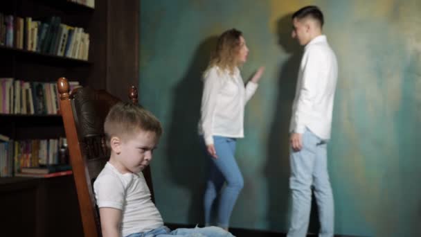 Triste menino está ouvindo pais divorciados lutar . — Vídeo de Stock